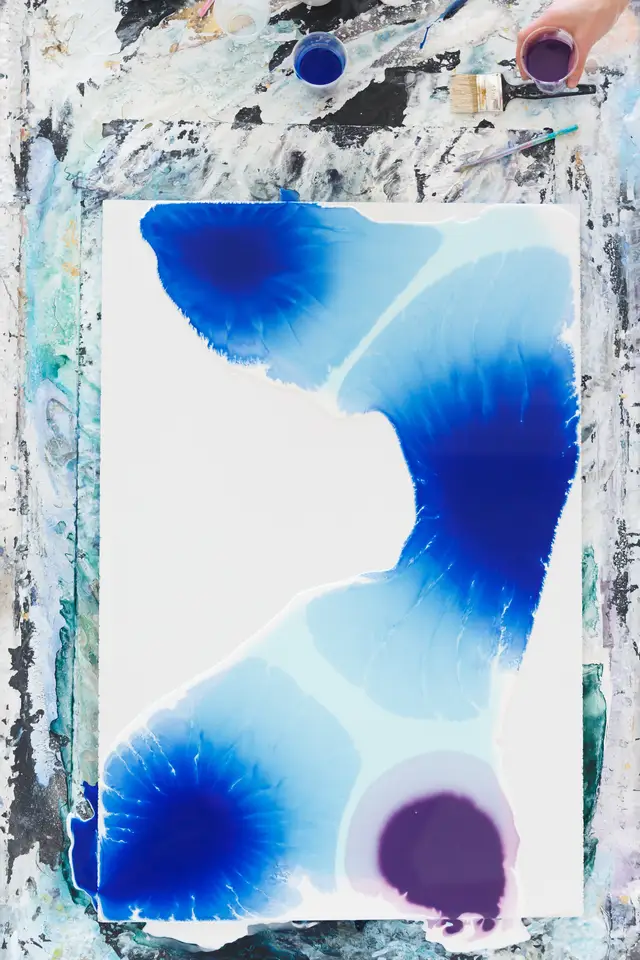 Detail of an abstract painting with deep blue, pale turquoise, white, and warm ochre passages